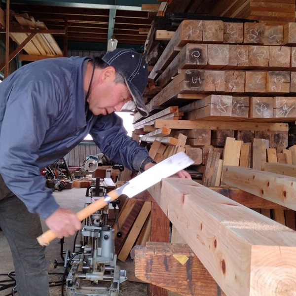 代表藤原虎雄が木を切る姿